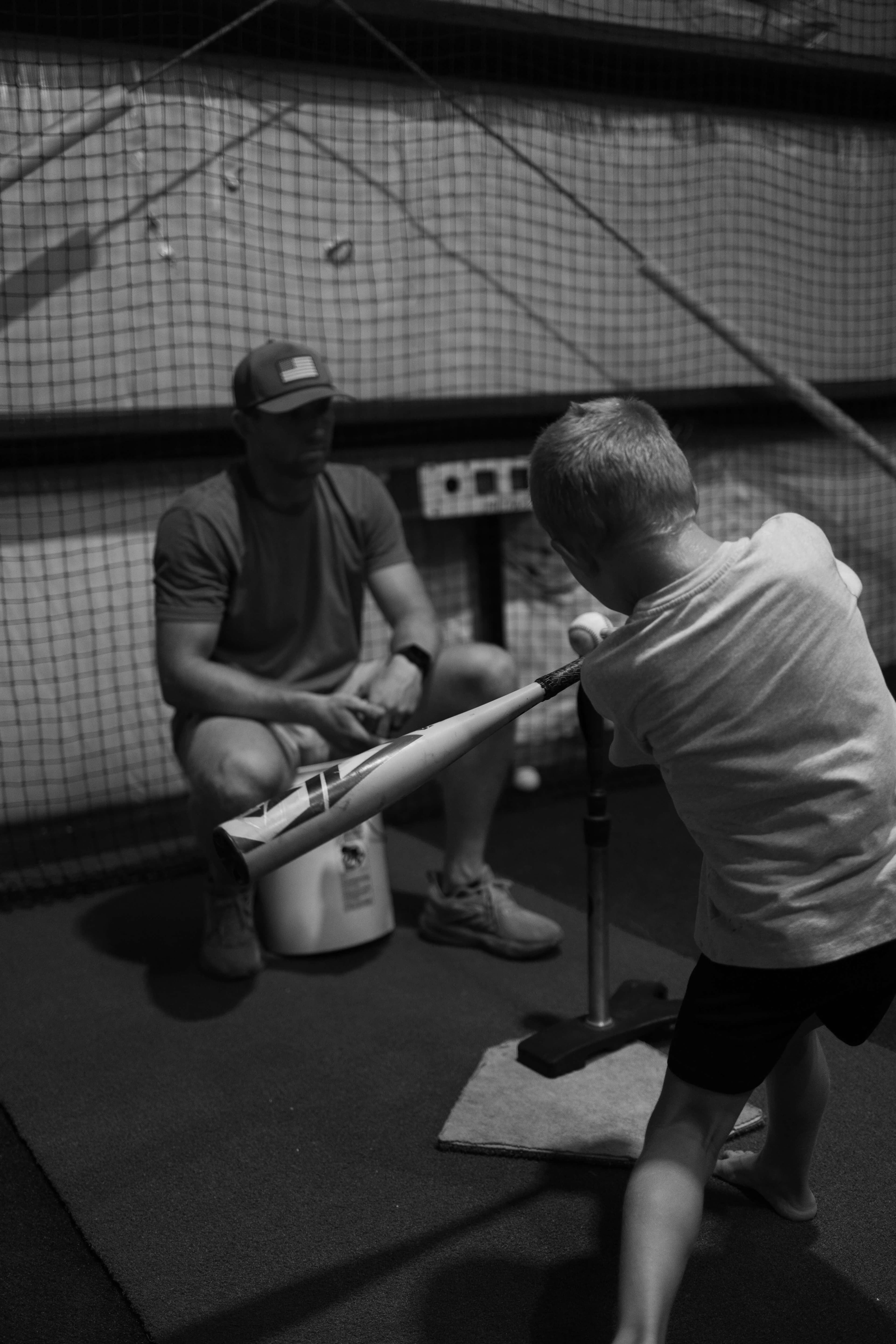 Youth baseball player receiving one-on-one batting instruction from a coach at Kingdom Built Performance in Santa Rosa Beach